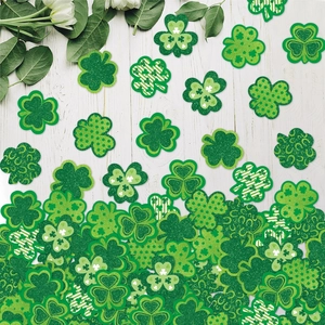 Saint Patrick's Day clover confetti assortment with glitter and striped patterns on wood