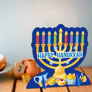 Hanukkah table decor featuring a Menorah and Happy Hanukkah text on wooden desk