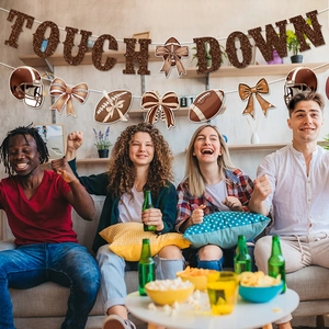 Glittering Touch Down banner and coquette football spiral swirls in a cozy party setting