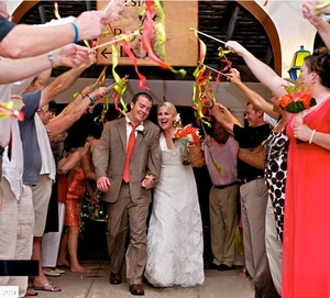 Wedding ribbon wands with colorful lace and bells being waved for the bride and groom