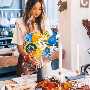 Close-up of Hanukkah menorah and dreidel paper toppers being placed in a vase for decor