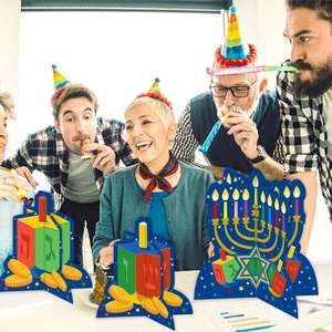 Hanukkah party table decorations featuring 3D paper Menorah and Dreidel centerpieces