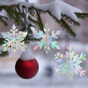 Iridescent 3D hollow snowflake ornaments hanging on snowy pine branches for Xmas
