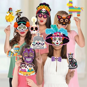Group of women holding colorful Day of the Dead photo booth props with sugar skull masks