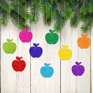 Lot de pendentifs pommes pailletées sur mur en bois blanc pour décor d'école