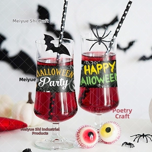 Close-up of Happy Halloween decorative stickers on glasses with bat straws and pumpkins