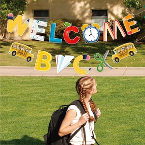 Outdoor setup of colorful Welcome Back school banner with school bus and pencil icons