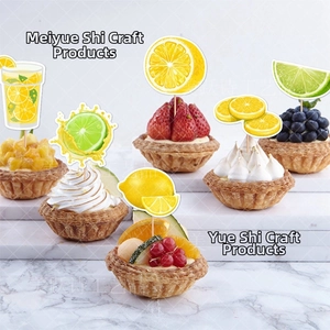 Detailed close-up of lemon and lime themed cupcake toppers on fresh fruit tarts