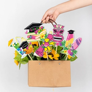 Graduation party photo props with tropical summer motifs held in a sunflower bouquet bag