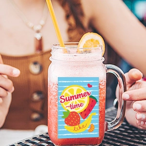 Mason jar with colorful summer time stickers and fresh juice for a Hawaii party