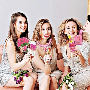 Women celebrating Mother's Day with colorful party photo booth props and accessories