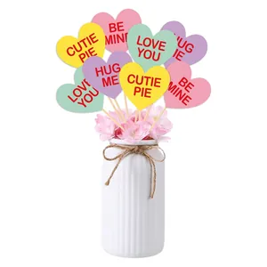 Pastel heart-shaped Valentine's Day party toppers in a white vase with cherry blossoms