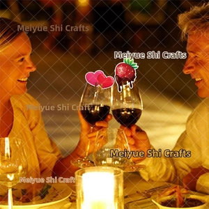 Romantic candlelit dinner featuring red heart and strawberry wine glass charms