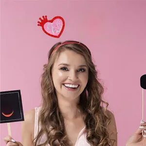 Detail eines roten Valentinstag-Haarreifs mit rosa Glitzerherz und Kiss Me Text