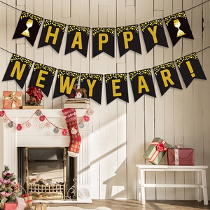 Schwarz-goldene Happy New Year Girlande über einem festlich dekorierten Kamin