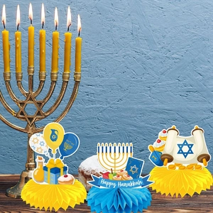 Three Happy Hanukkah honeycomb centerpieces with Menorah and Torah on a wooden desk