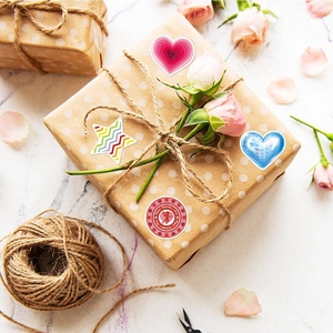 Assorted Valentine heart and star stickers on craft paper gift box with marble background
