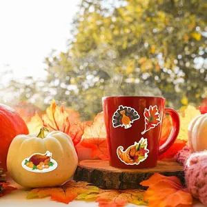 Thanksgiving turkey and maple leaf stickers displayed with autumn decor on wood