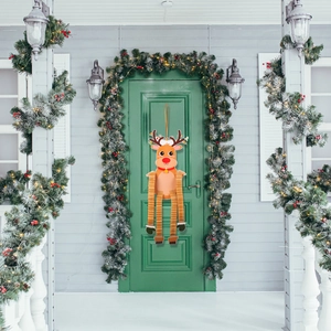 Décoration de renne de Noël avec jambes en papier nid d'abeille sur porte en bois verte
