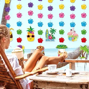 Hawaiian party decoration set with flamingo, pineapple and flower garlands on a beach