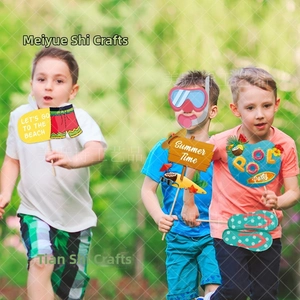 Close-up of paper summer photo booth props with pool party and beach-themed patterns
