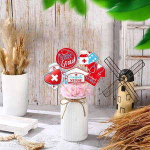 Nurse graduation party decorations with medical theme inserts in a floral vase display