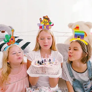 Three children wearing Mexican party headbands with cactus, taco, and pinata designs
