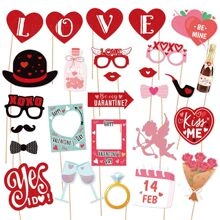 Flat lay of Valentine party props including heart glasses, love signs and photo booth items