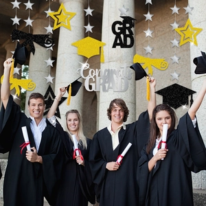 Glittery graduation hanging decorations with stars and grad caps against graduates background