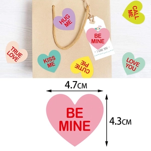 Colorful heart-shaped Valentine stickers with romantic phrases for gift packaging