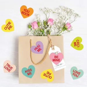 Colorful Valentine's heart stickers with romantic phrases on white wood background