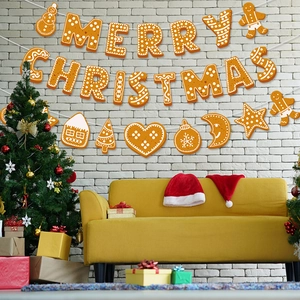 Gingerbread style Merry Christmas banner with snowman and tree hanging on white brick wall