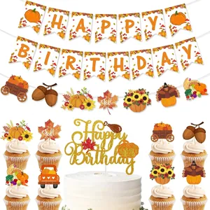 Close-up of autumn harvest birthday party banner, glittery pumpkin cake topper and fall decor