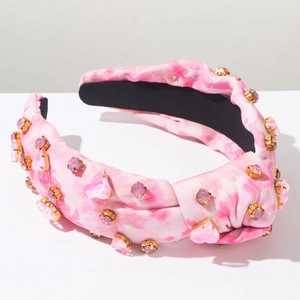 Close-up of pink tie-dye knot headband featuring sparkling heart-shaped rhinestones