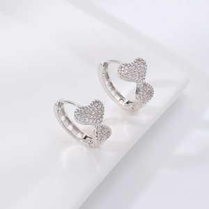 Detailed macro view of heart-shaped silver earrings with micro-paved cubic zirconia