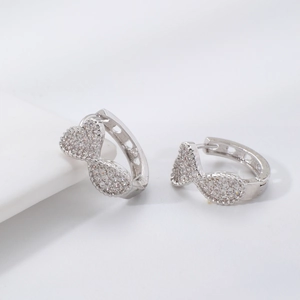 Detailed close-up of silver bow earrings encrusted with micro-pave white cubic zirconia