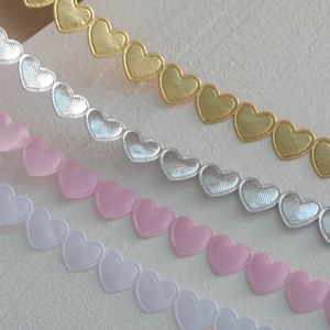 Lace ribbon with continuous heart patterns in gold, silver, pink, and white for gift wrapping