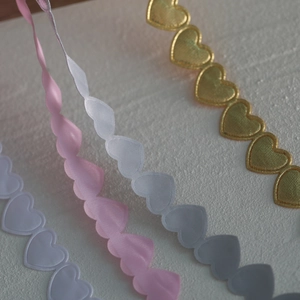 Macro detail of heart-shaped satin ribbons for gift wrapping and DIY crafts