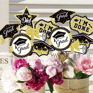 Glittery black and gold graduation centerpieces in a flower vase for party decor