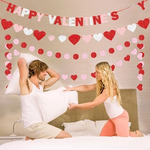 Romantic Valentine's Day party room setup with red glitter heart banners and happy wishes