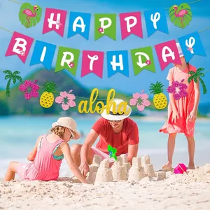 Tropical Hawaii Aloha Party banner and Happy Birthday decorations on a beach