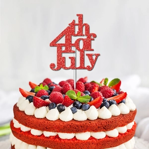Close-up of red glitter 4th of July cake topper with artistic font on a red velvet cake