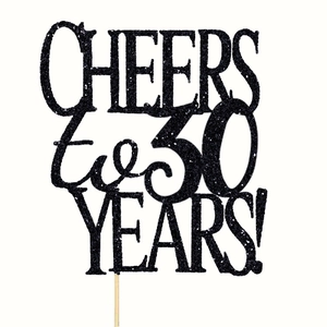 Macro shot of black glitter 30th anniversary cake topper with Cheers to 30 Years text
