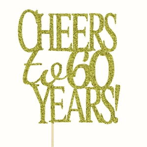 Close-up of golden glitter 'CHEERS to 60 YEARS' cake topper for diamond anniversary