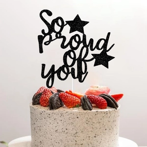 So Proud of You graduation cake topper with black glitter finish on a cream cake