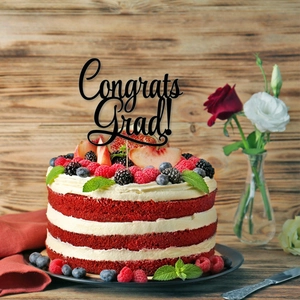 Elegant black acrylic Congrats Grad cake topper on a fruit red velvet cake decoration