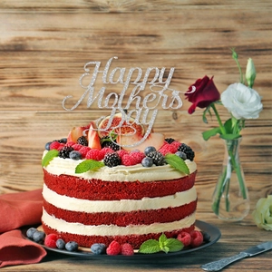Macro detail of glittery silver Happy Mother's Day cake topper on a red velvet cake