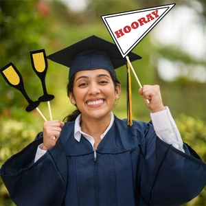 Smiling graduate holding glittery champagne props and a Hooray flag for party photos