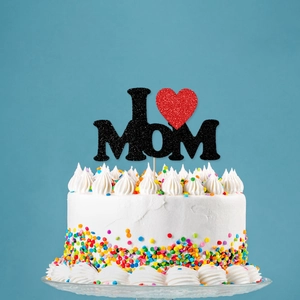 Glittery I Love MOM cake topper with red heart on a white cake for Mother's Day party
