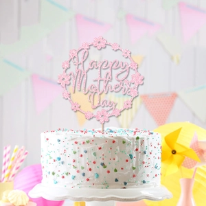 Pink glitter Happy Mother's Day cake topper with floral border on a cream cake